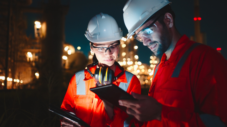Team Inspection engineers working with laptop of oil factory and gas refinery plant industry at night for inspector safety quality control.